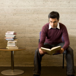 Young man reads and studies in a library