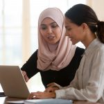 Focused muslim female mentor teacher teaching intern worker learning new skills